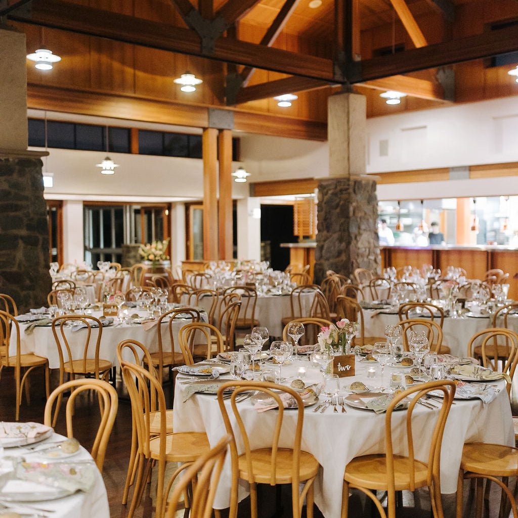 Lurleen's Dining hall with wooden beams and tables set for a meal.