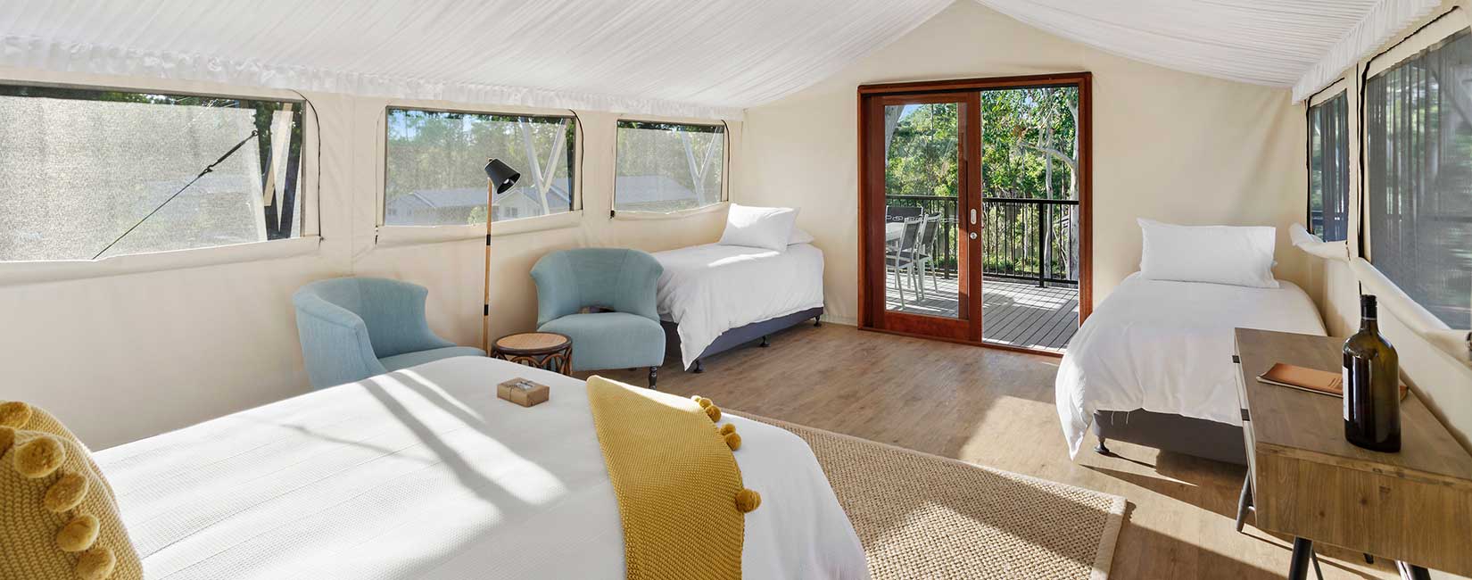 Interior of Family pavilion showing beds and sofas with view to bushland