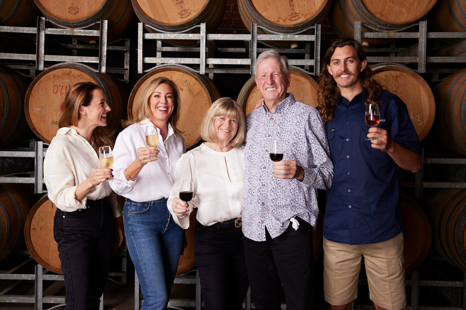 The Sirromet family smiling in front of a wine vat