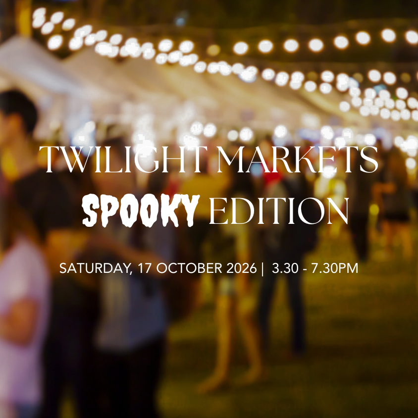 Promotional graphic for 'Twilight Markets Spooky Edition' with white text over a blurred nighttime market scene featuring string lights and people walking under tents.