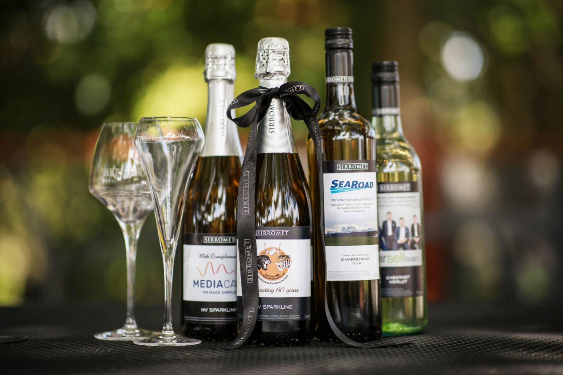 Selection of Sirromet customised wine label bottles and two wine glasses