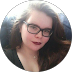 Wona (Emily Hunter) wearing glasses with a blurred background