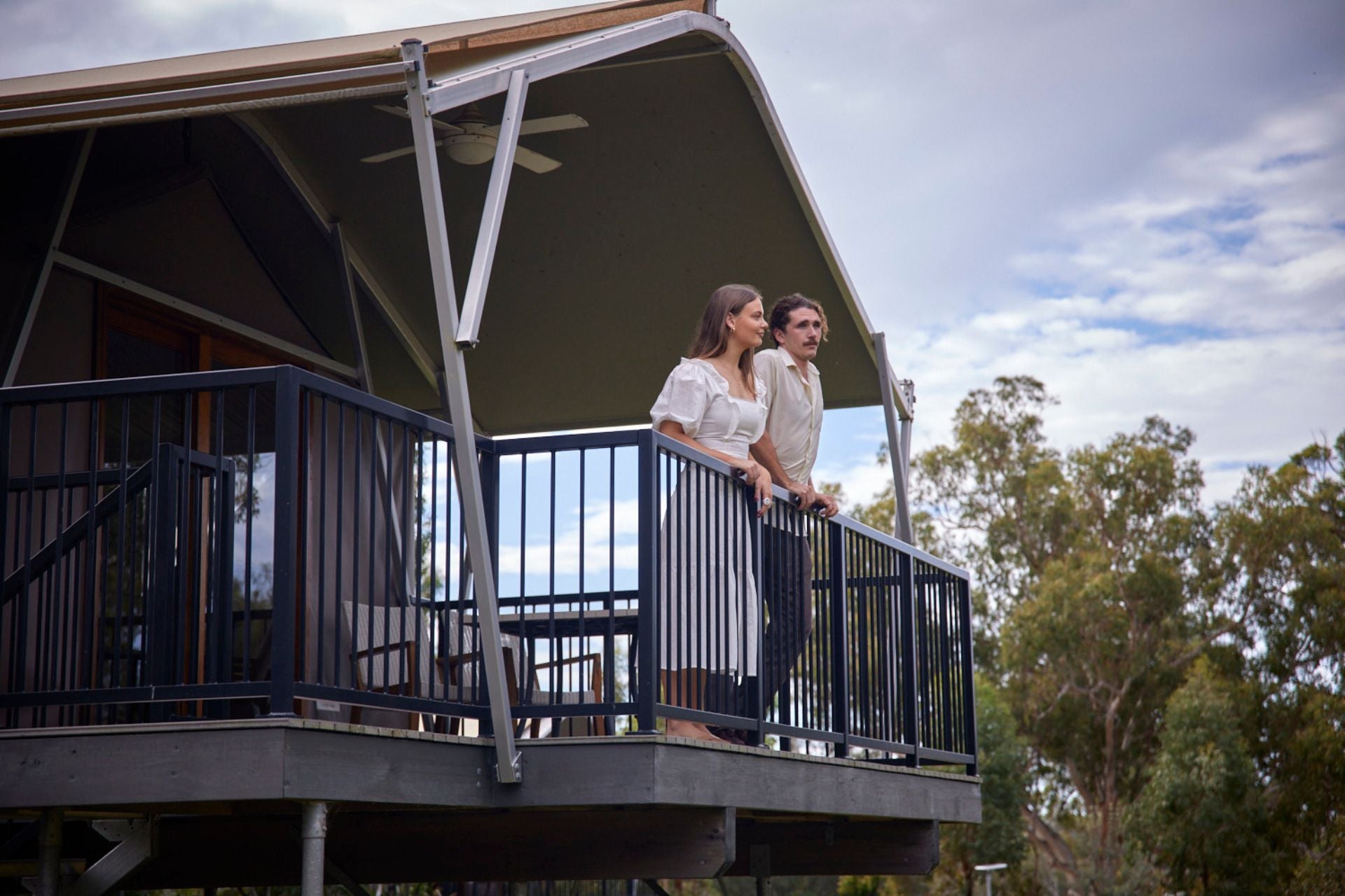Couple standing on the deck of the Lugana luxury pavilion