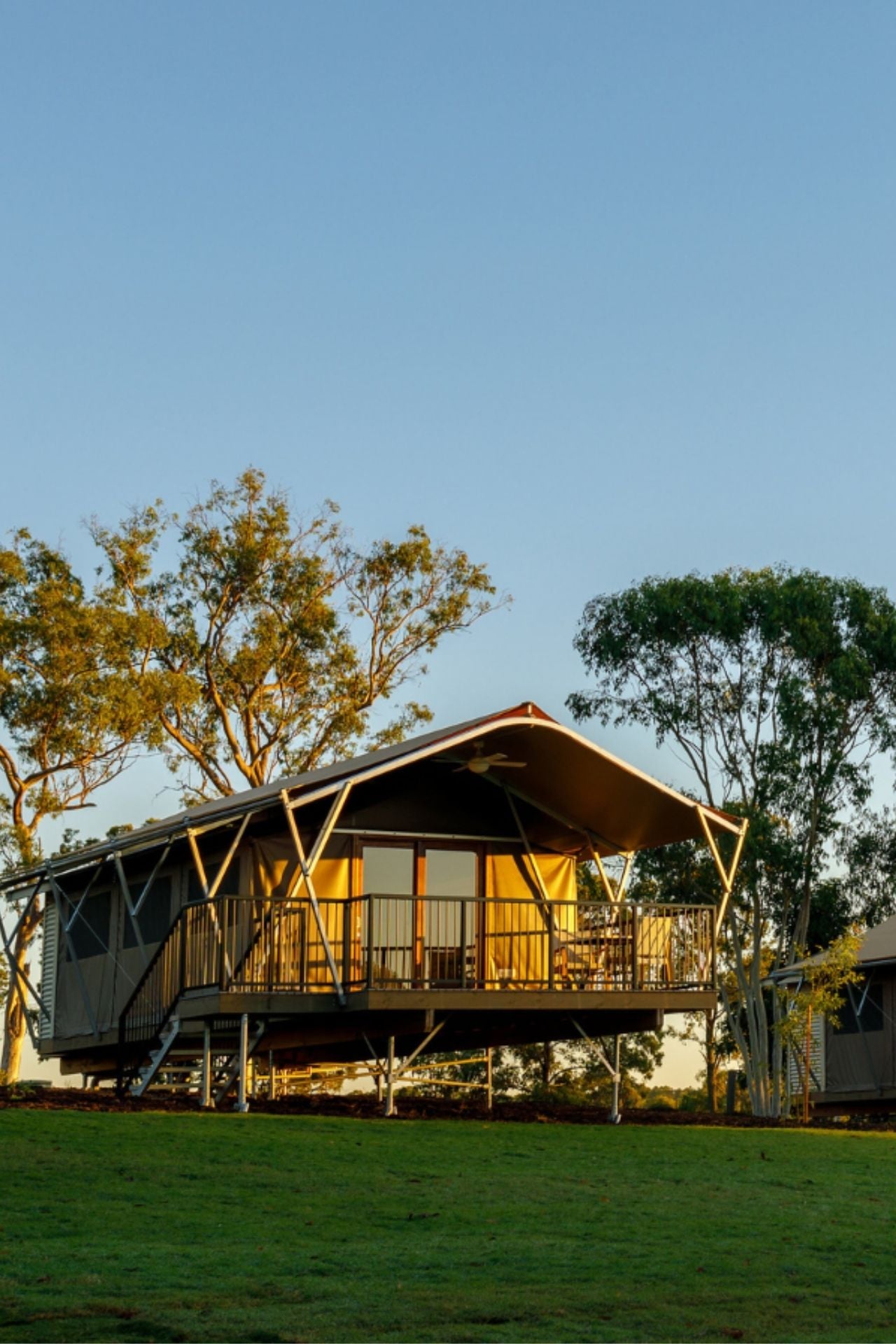 Front view of a luxury pavilion with the sun setting on the deck
