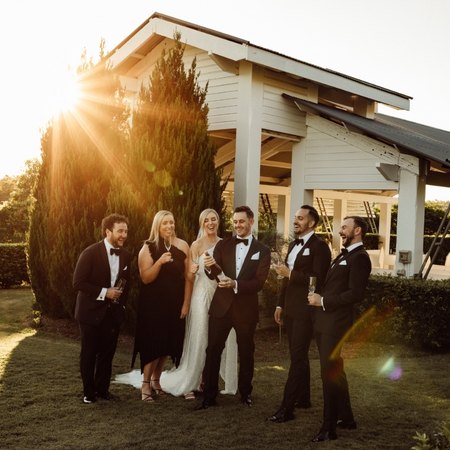 Wedding party sipping champoagne outdoors as the sun sets