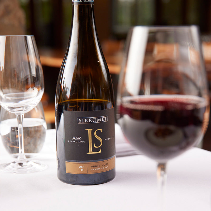 Bottle of Le Sauvage wine and two wine glasses